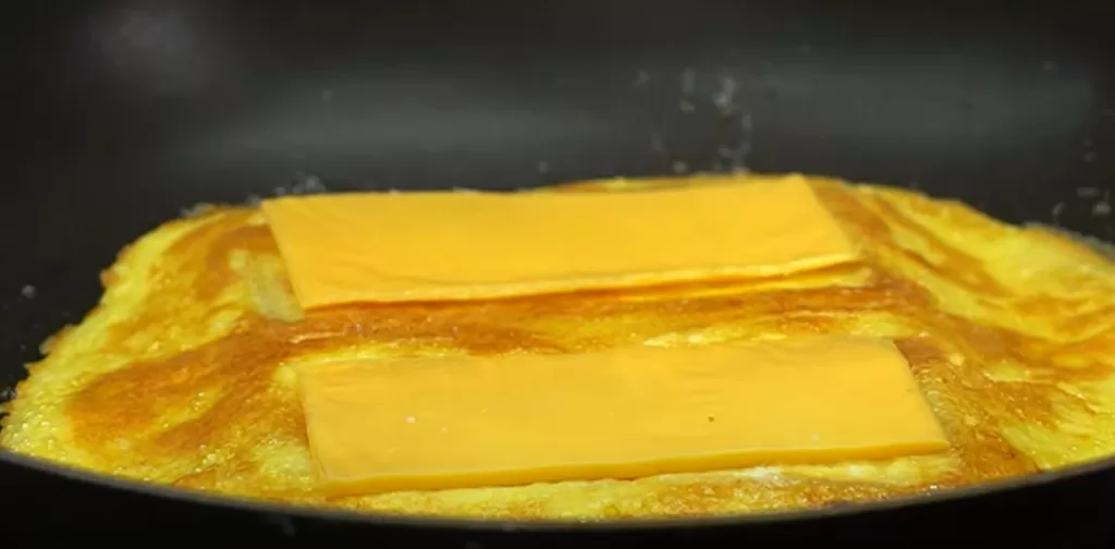 Na omeletu položíme plátky taveného sýra