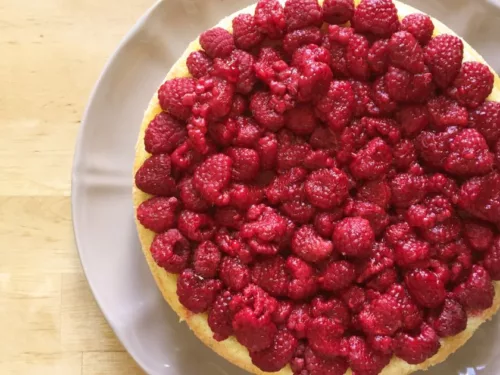 Obrázek receptu na letní ovocný dort s malinami na povrchu.
