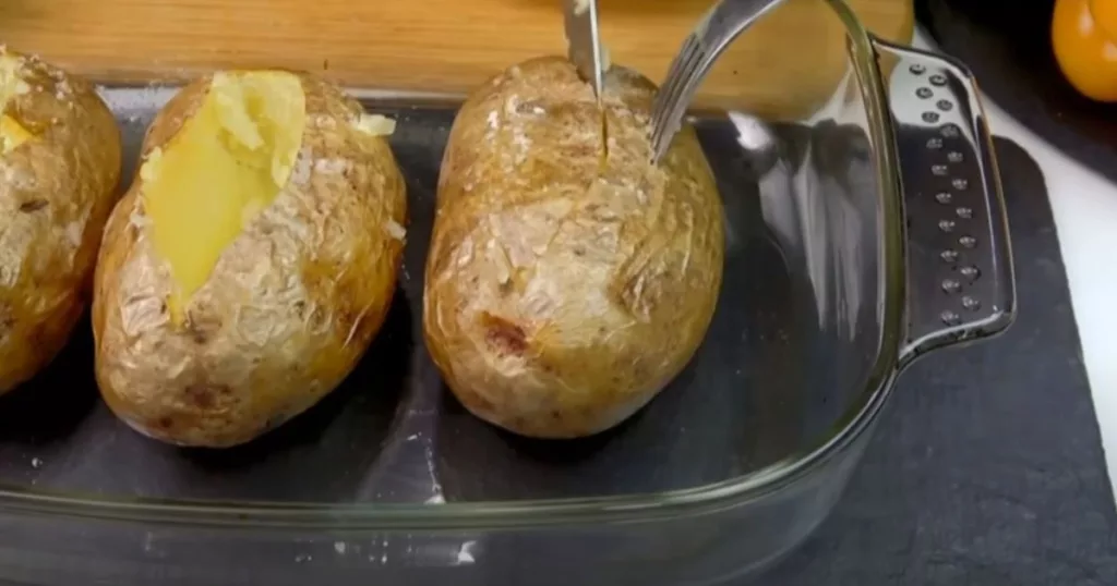 Upečené brambory vyndáme z alobalu a vykrojíme z nich středy, aby se daly brambory naplnit.