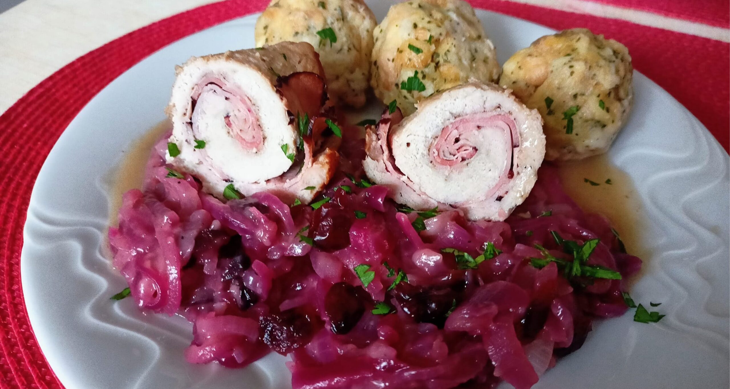 Obrázek receptu na vepřové závitky se zelím z červené cibule a karlovarským knedlíkem.