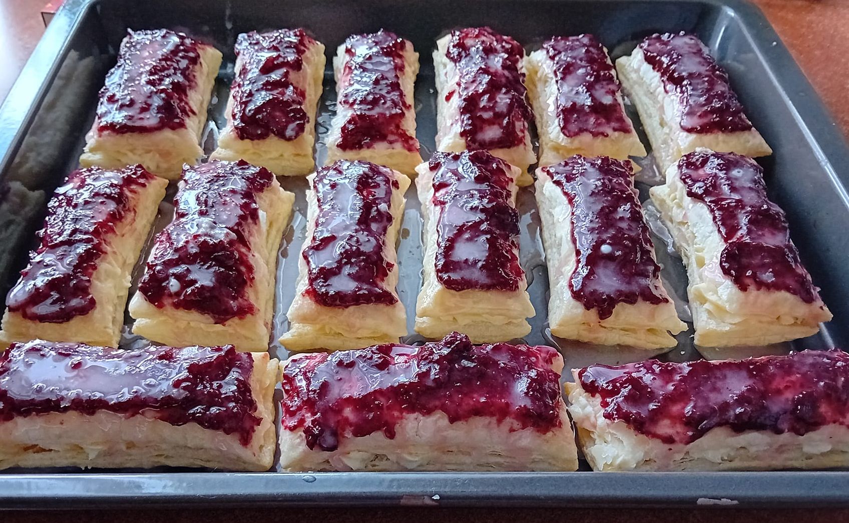 Obrázek k receptu na Křehké kremžské řezy s vanilkovým krémem, ostružinovou marmeládou a citronovou polevou